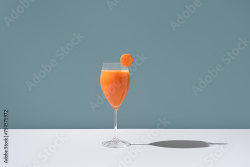 Elegant glass of carrot juice with a slice on the rim photo