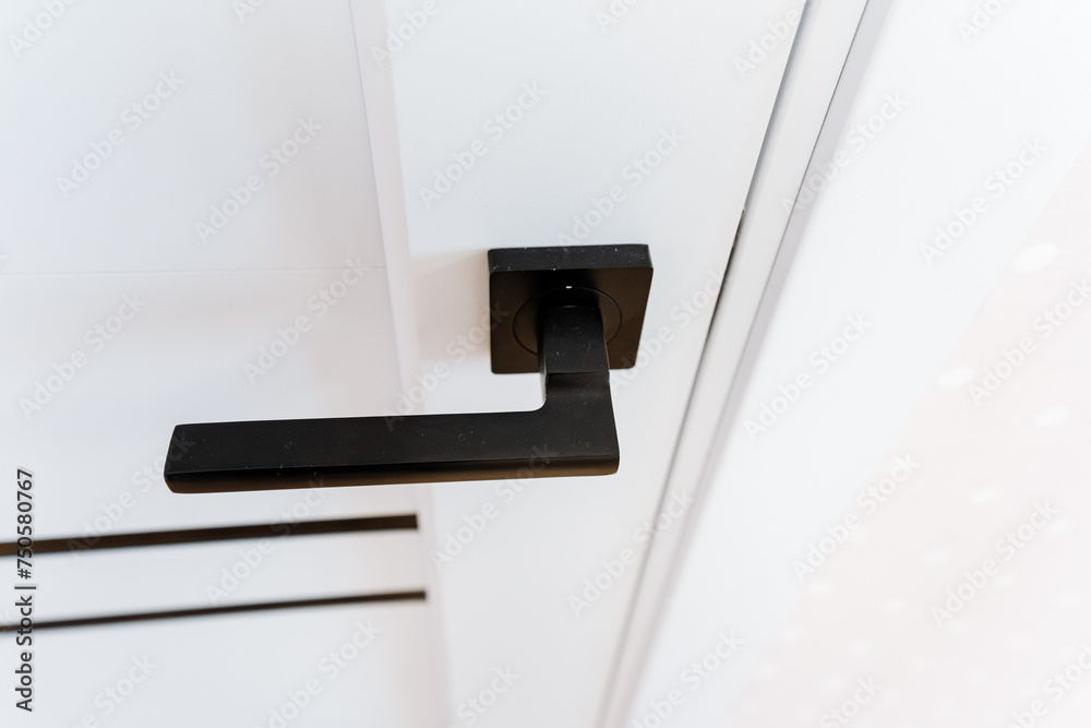 Closeup of a dark wood door handle on a white door Closeup of a dark wood door handle on a white door