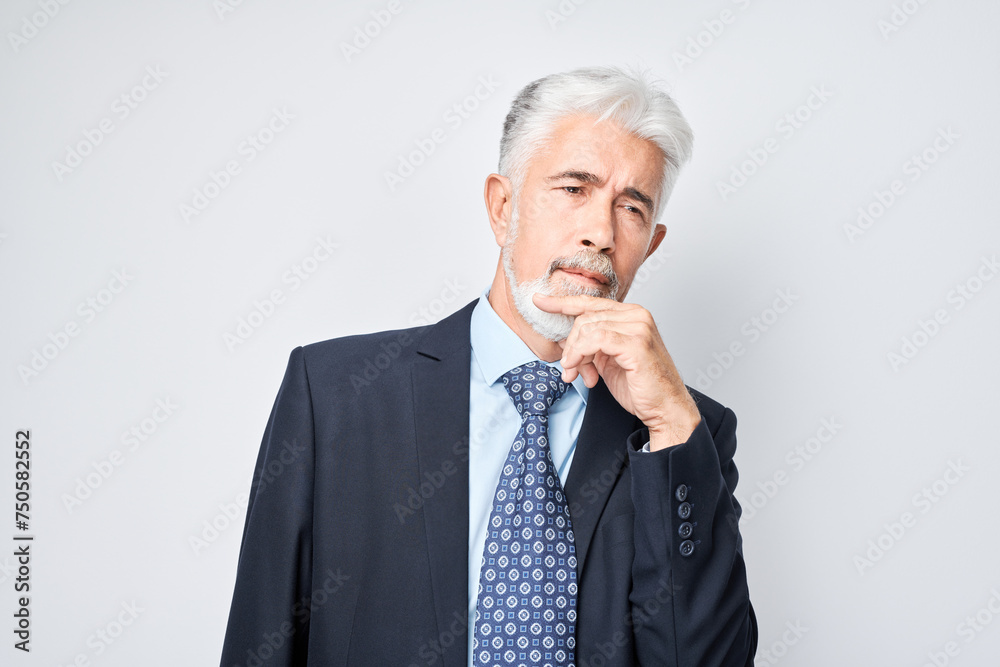 Thoughtful senior businessman hand on chin, contemplating isolated on a light background. Thoughtful senior businessman hand on chin, contemplating isolated on a light background.