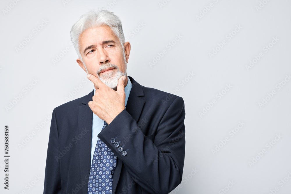 Thoughtful senior businessman hand on chin, contemplating isolated on a light background. Thoughtful senior businessman hand on chin, contemplating isolated on a light background.