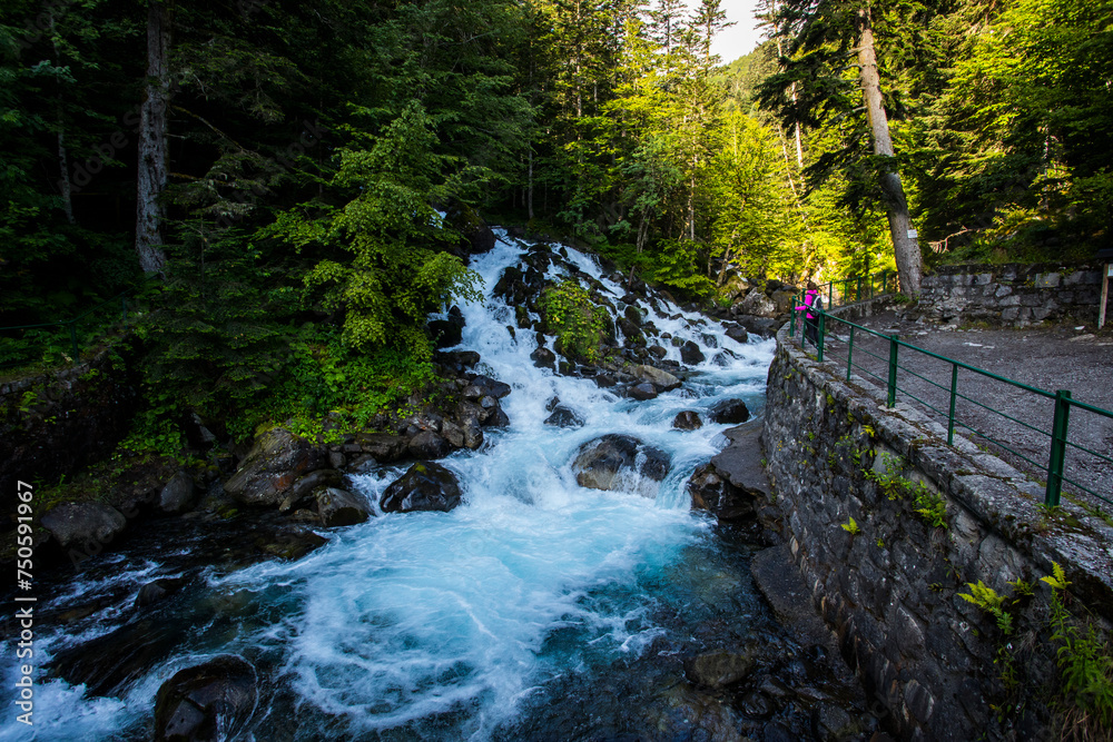Fototapeta premium Summer and young girl in Uelhs Deth Joeu waterfall, Val D Aran, Spain