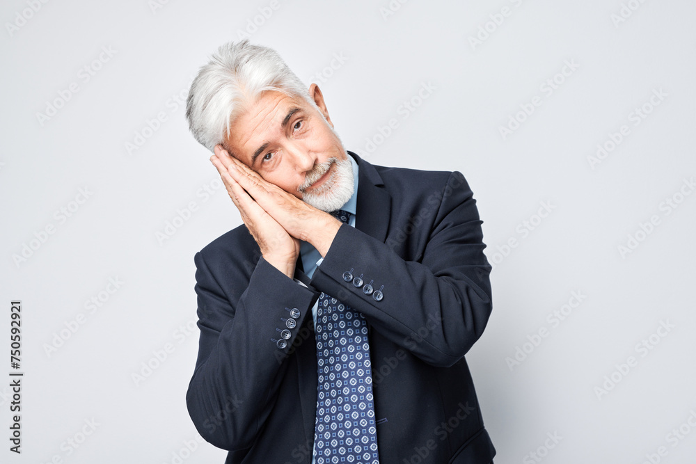 Senior businessman in suit pretending to sleep with hands clasped together like a pillow. Senior businessman in suit pretending to sleep with hands clasped together like a pillow.