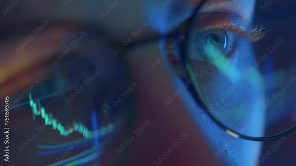 Trader wearing glasses is working on laptop computer. Screen with stock market charts and Bitcoin BTC or Ethereum ETH data analysis reflection. Broker trading online. Altcoins crypto currency trading