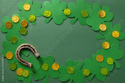 St. Patrick's day frame with clover leaves, horseshoe and coins on green background. Flat lay. View from above. Greeting card with copy space.