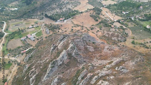An aerial perspective of a treecovered mountain surrounded by natural landscape, with plant life thriving on the bedrock outcrops and hills, creating a picturesque view photo