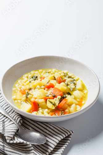 Israeli soup with ptitim, vegetables and spinach.