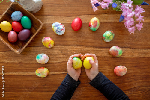 Little blond toddler boy child coloring easter eggs at home, Czech Republic tradition