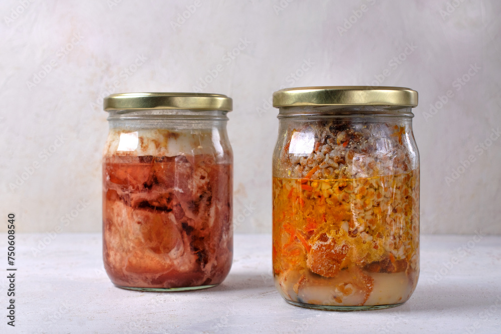 Different canned stewed meat. Two glass jars with canned pork and buckwheat, prepared preserved meal Different canned stewed meat. Two glass jars with canned pork and buckwheat, prepared preserved meal