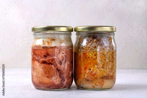 Different canned stewed meat. Two glass jars with canned pork and buckwheat, prepared preserved meal