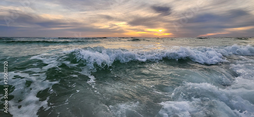 A scenic sunset view of ocean waves surf breaking on the beach at the Gulf Islands National Seashore in Pensacola, Florida.