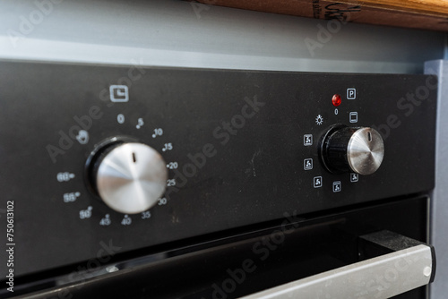 Kitchen appliance Close up of a black oven with silver knobs