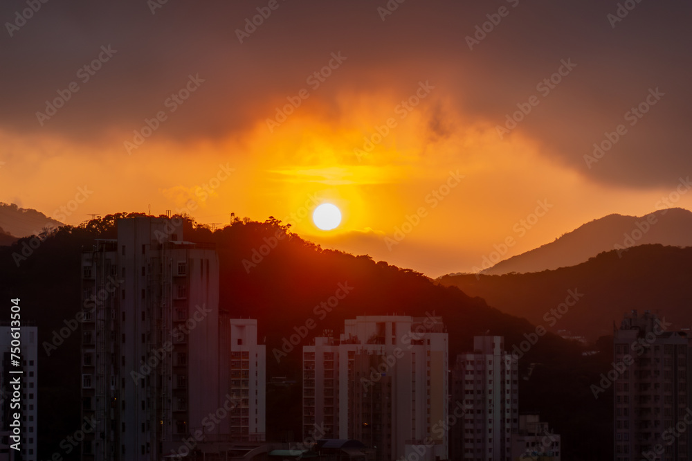 sunset over city with silhouettes apartment building Hong Kong