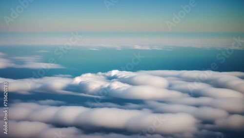 A celestial dance unfolds as sunlight kisses the morning sky, painting a breathtaking panorama of clouds below.
