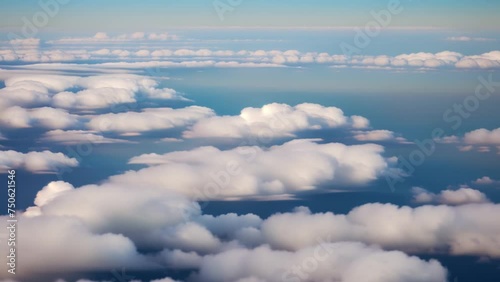 A bird's eye perspective reveals a symphony of blue hues, where clouds dance in the vast expanse of sky.
