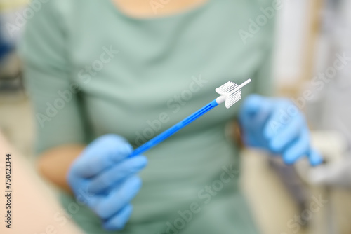Gynecologist examines a patient takes a smear from a woman cervix. Close up view of doctor hands with gynecological cytobrush. Diagnosis of female viral and infection diseases photo