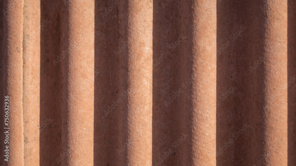 Wavy orange background with shadows. Red wavy wall in the sun Wavy orange background with shadows. Red wavy wall in the sun
