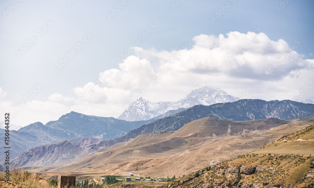 Fototapeta premium Panorama of mountain ranges and peaks of the Fan Mountains with glaciers, rocks and vegetation in Tajikistan on a summer sunny day