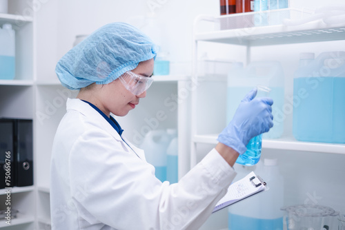 Woman scientist chemist holding laboratory blue liquid beaker test tube equipment for discovery analysis science chemical medicine development experiment technology biotechnology development