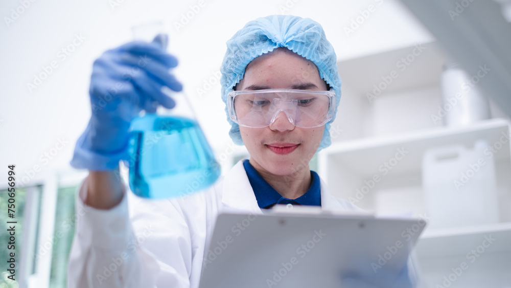 Woman scientist chemist holding laboratory blue liquid beaker test tube equipment for discovery analysis science chemical medicine development experiment technology biotechnology development Woman scientist chemist holding laboratory blue liquid beaker test tube equipment for discovery analysis science chemical medicine development experiment technology biotechnology development