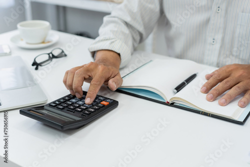 Fototapeta Naklejka Na Ścianę i Meble -  businessman hand using calculator Calculating bonus(Or other compensation) to employees to increase productivity.