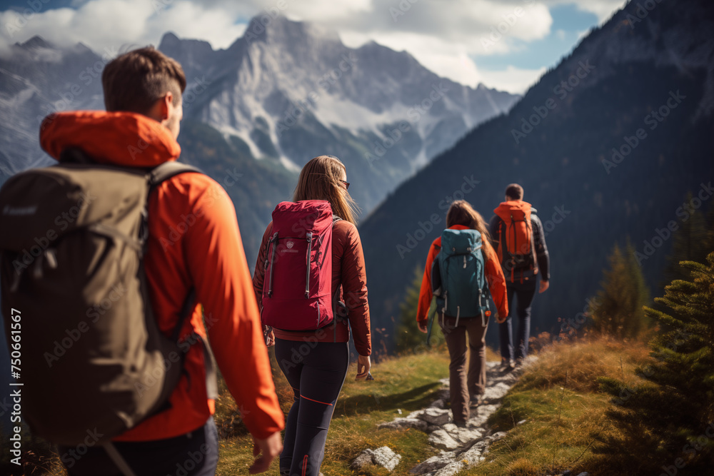 A group of tourists with backpacks descends a mountain trail during a hiking expedition.