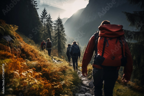 A group of tourists with backpacks descends a mountain trail during a hiking expedition. photo