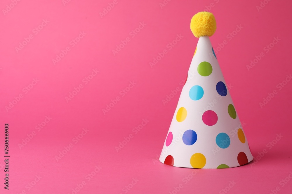 One beautiful party hat with pompom on pink background, space for text One beautiful party hat with pompom on pink background, space for text