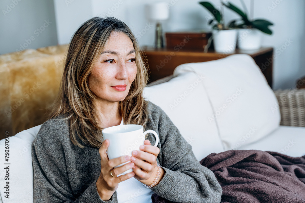Asian woman spending great time at home drinking coffee, hot chocolate, tea, listening to music, communicating with family. Lifestyle concept Asian woman spending great time at home drinking coffee, hot chocolate, tea, listening to music, communicating with family. Lifestyle concept