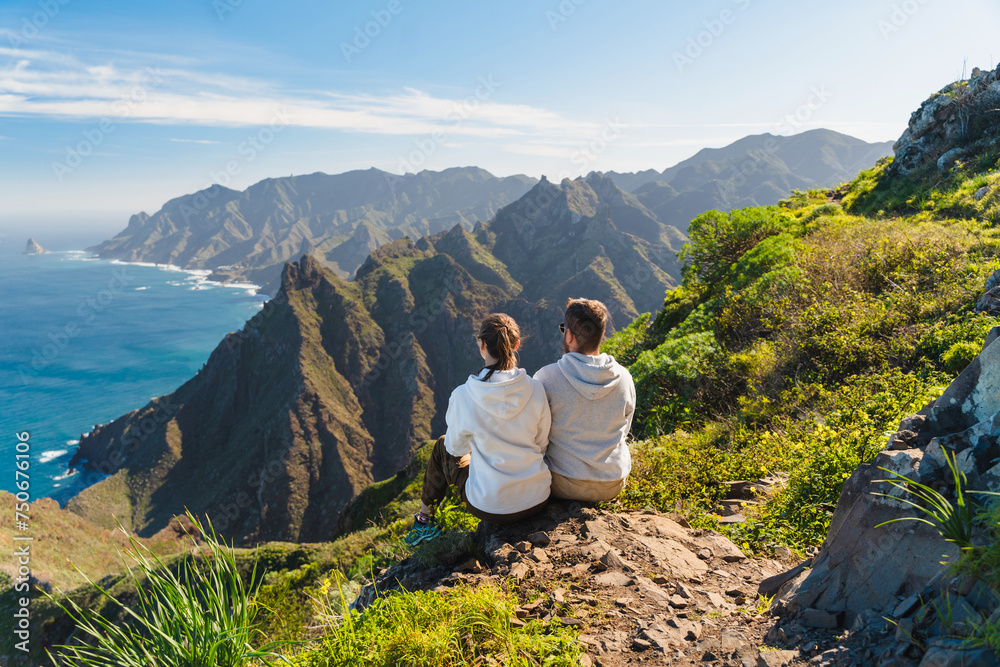 Naklejka premium Couple enjoying vacation in nature. Hikers watching beautiful coastal scenery.