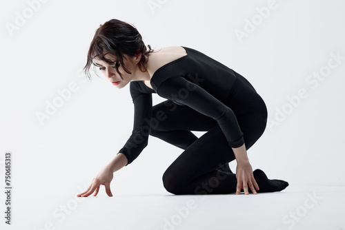 Finding inner-self. Young slim woman in black clothes, dark makeup look and artistic face posing against white studio background. Concept of self-care, beauty, psychology, emotions and feelings