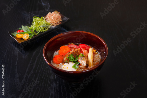 Bun ca, Vietnamese rice noodles and grilled chopped fish, Vietnamese food isolated on black wood table background