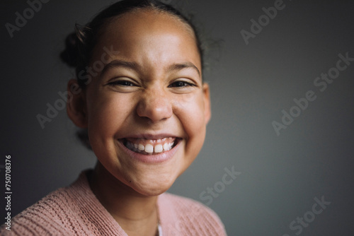 Portrait of happy girl against gray background photo