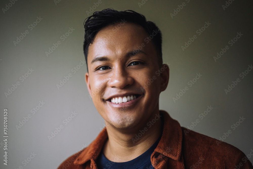 Portrait of smiling man in front of wall at home Portrait of smiling man in front of wall at home