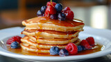 A stack of delicious blueberry pancakes drizzled with honey and syrup.