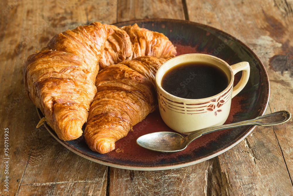 Traditional french breakfast: cup of coffee and hot croissants on a wooden background Traditional french breakfast: cup of coffee and hot croissants on a wooden background