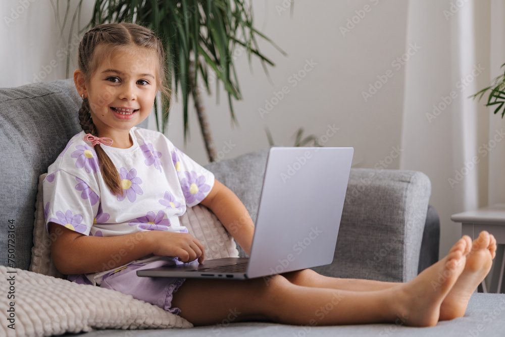 Happy and smart little girl using laptop at home. Five year old girl try to use smart devise Happy and smart little girl using laptop at home. Five year old girl try to use smart devise