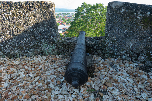 Baubau, Indonesia -March 1, 2024 -The Historic Cannons of the Buton Palace Fort Overlooking the Modern City View photo