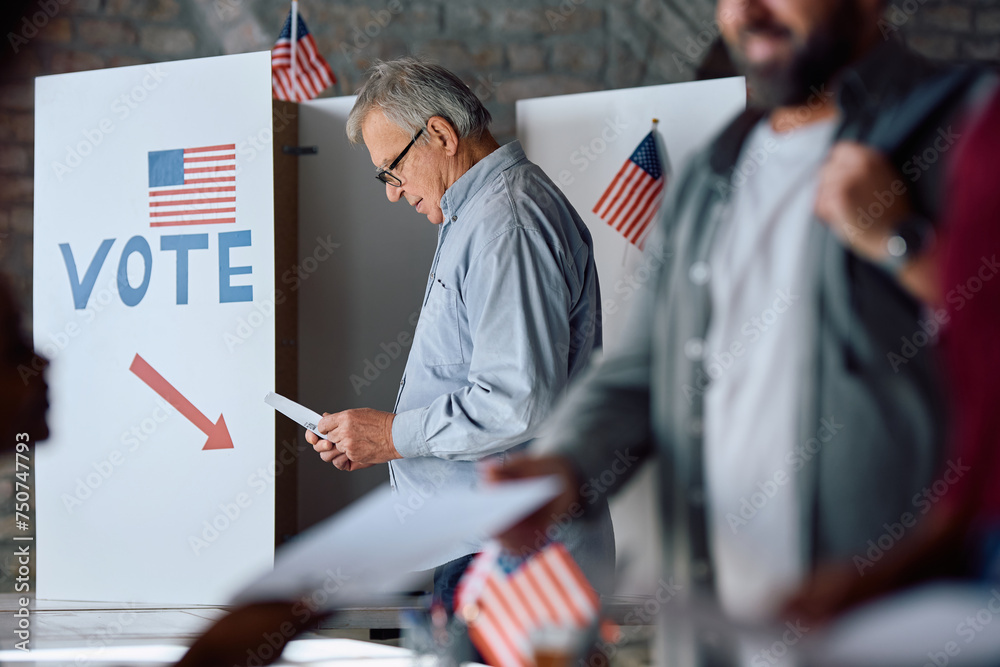 Senior US citizen at voting booth at polling station. - obrazy, fototapety, plakaty 