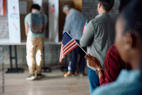 Close up of black voter with national flag in waiting line during US elections. photo