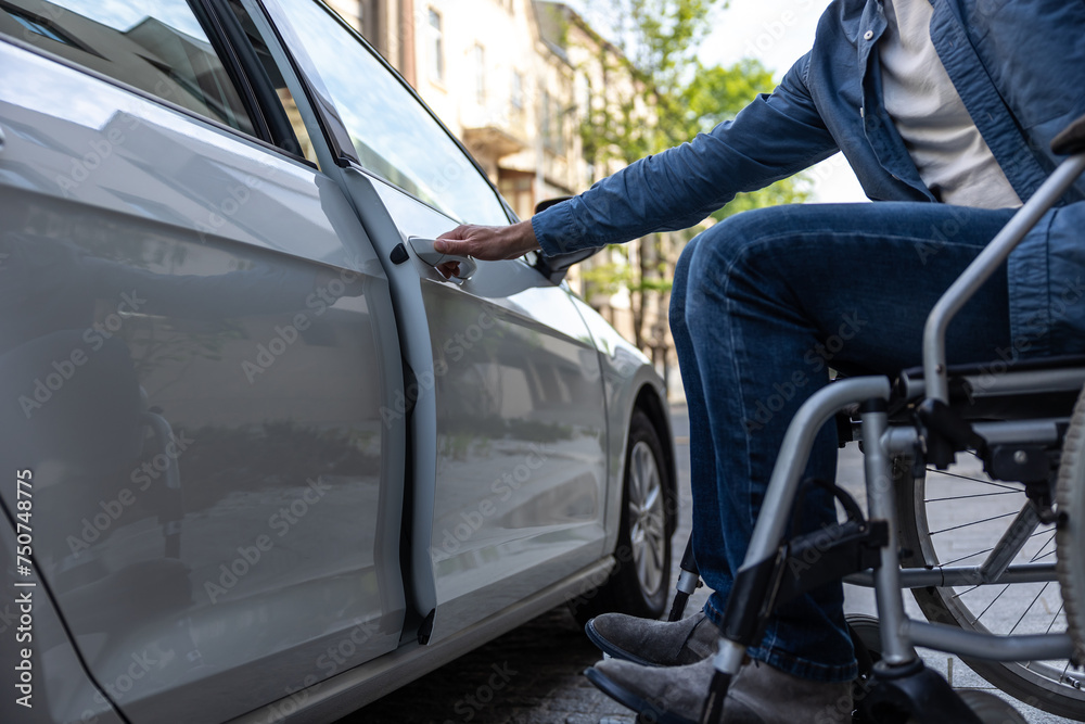 Disabled man in a wheelchair getting in a car Disabled man in a wheelchair getting in a car