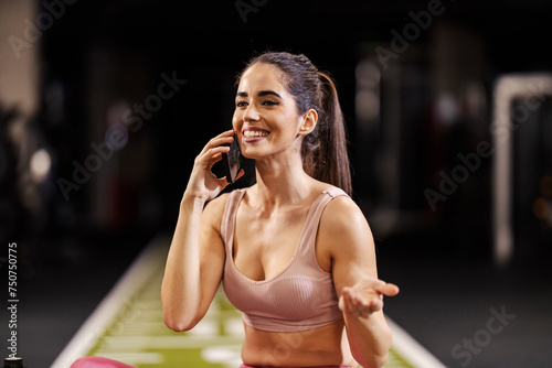 Portrait of a sportswoman talking on a cellphone in a gym.