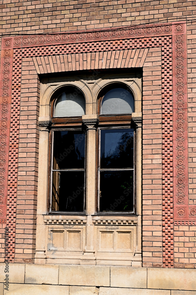 Medieval wooden decorative window in an old brick home