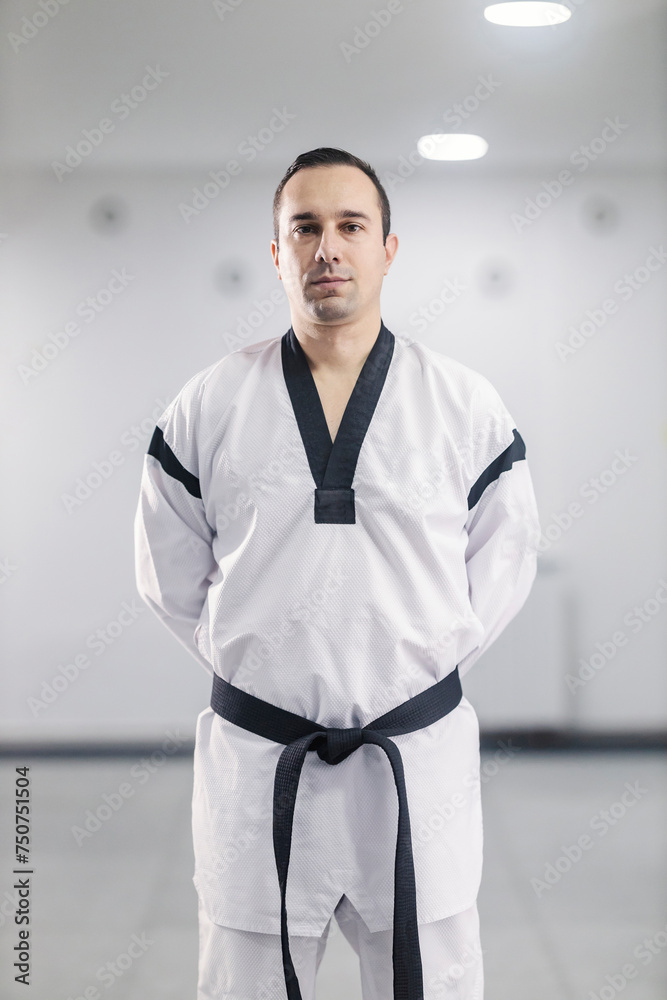A taekwondo master in kimono wearing black belt at martial art school.