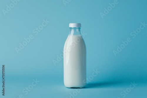A bottle of milk is placed on a uniform blue background, creating a simple yet striking visual contrast.