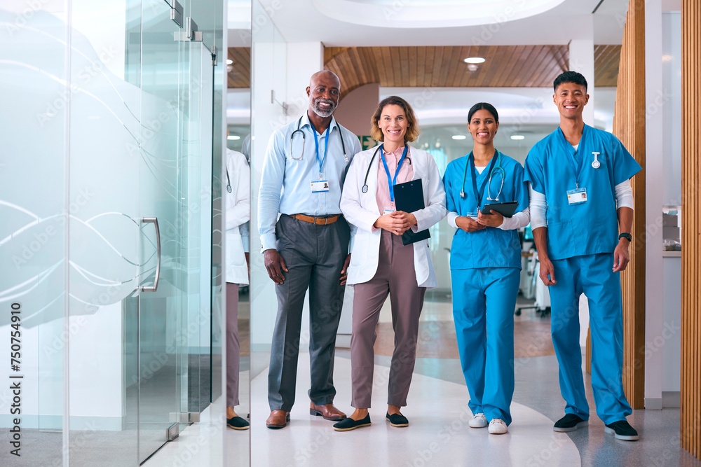Portrait Of Smiling Multi Cultural Medical Team Wearing Scrubs And White Coats In Modern Hospital  - obrazy, fototapety, plakaty 