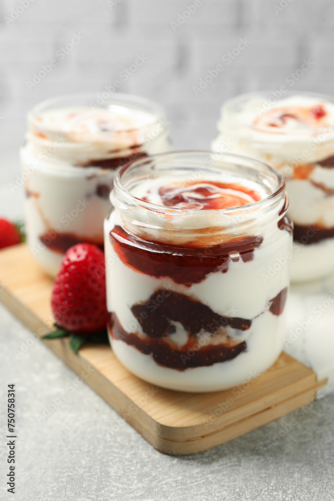 Tasty yoghurt with jam and strawberry on grey table, closeup Tasty yoghurt with jam and strawberry on grey table, closeup