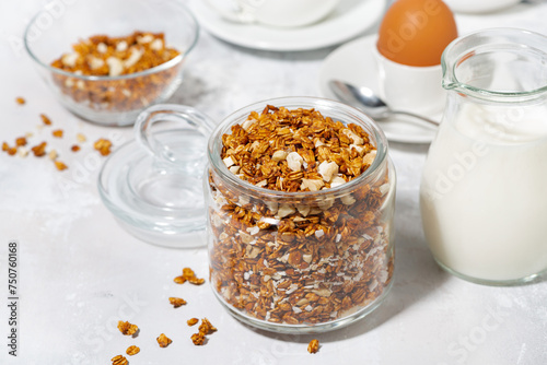 jar of granola with coconut and nuts on white background