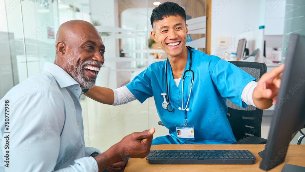 Fototapeta premium Male Doctor Wearing Scrubs At Hospital Appointment Giving Good News To Mature Male Patient 