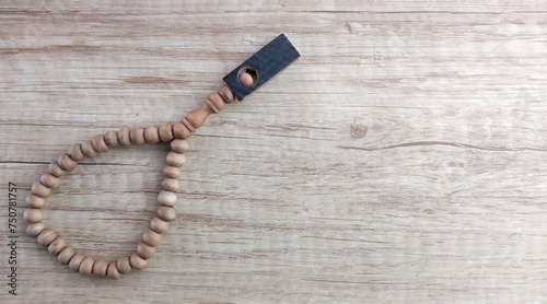 wooden rosary on a wooden background with space for text