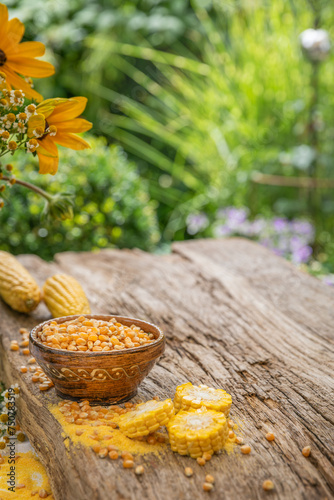 Ziarna kukurydzy w misce na drewnianym stole w ogrodzie.